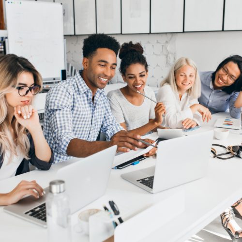 smiling-african-student-pointing-with-pencil-laptop-screen-concentrated-blonde-woman-glasses-propping-chin-with-hand-while-working-with-computer-office smiling-african-student-pointing-with-pencil-laptop-screen-concentrated-blonde-woman-glasses-propping-chin-with-hand-while-working-with-computer-office