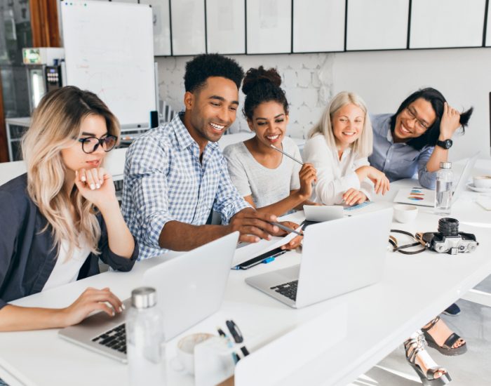 smiling-african-student-pointing-with-pencil-laptop-screen-concentrated-blonde-woman-glasses-propping-chin-with-hand-while-working-with-computer-office smiling-african-student-pointing-with-pencil-laptop-screen-concentrated-blonde-woman-glasses-propping-chin-with-hand-while-working-with-computer-office